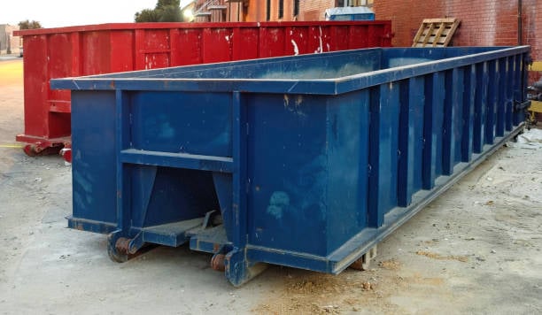 Commercial contractor overseeing safe waste loading into large dumpster at busy Franklin, TN job site