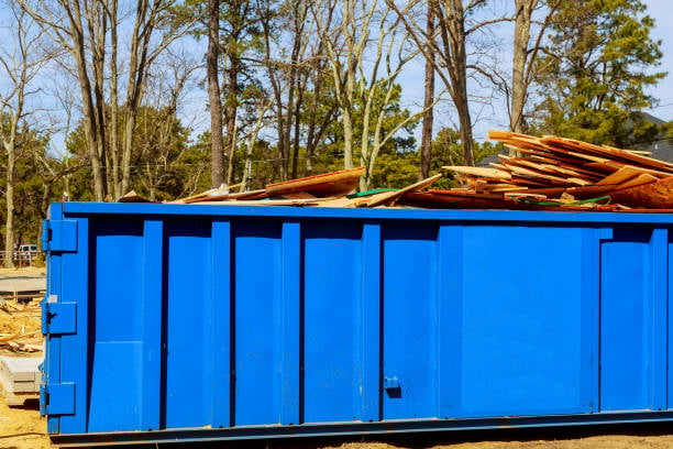 Commercial property manager overseeing cleanup crew loading debris into large dumpster at Cool Springs business complex