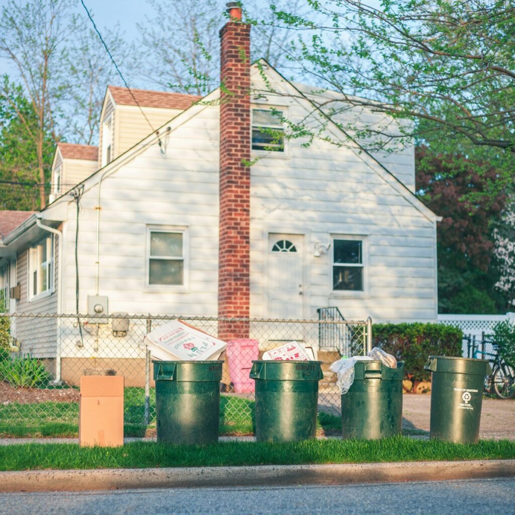 Commercial waste containers holding boxes and discarded materials for organized property cleanup, representing Commercial Dumpster Rental services near me.