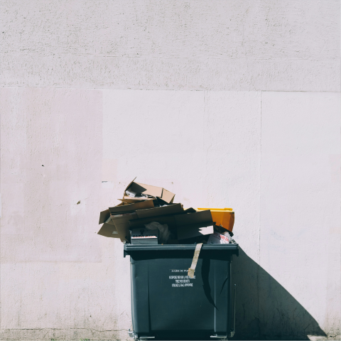 Commercial trash bin filled with cardboard and discarded materials for dumpster rental services in Green Hill, TN